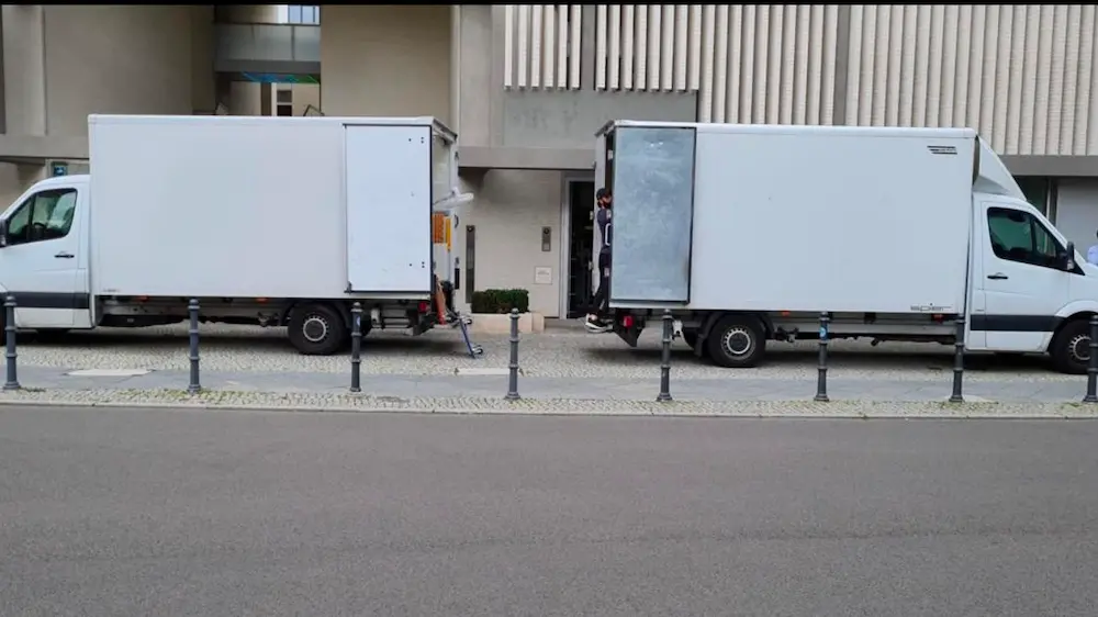 Zwei Umzugsfahrzeuge vor einem Bürogebäude in Berlin